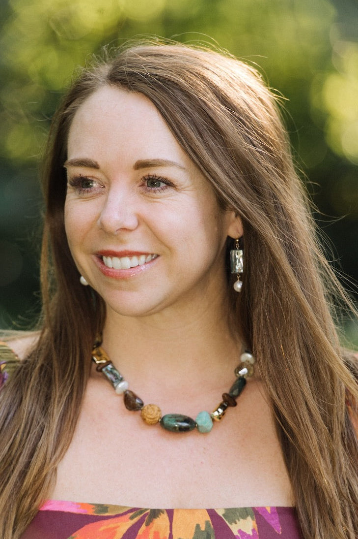 Woman wearing a colorful floral dress with a blurred green background