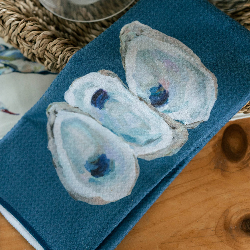 Blue towel with oyster design on a wooden surface