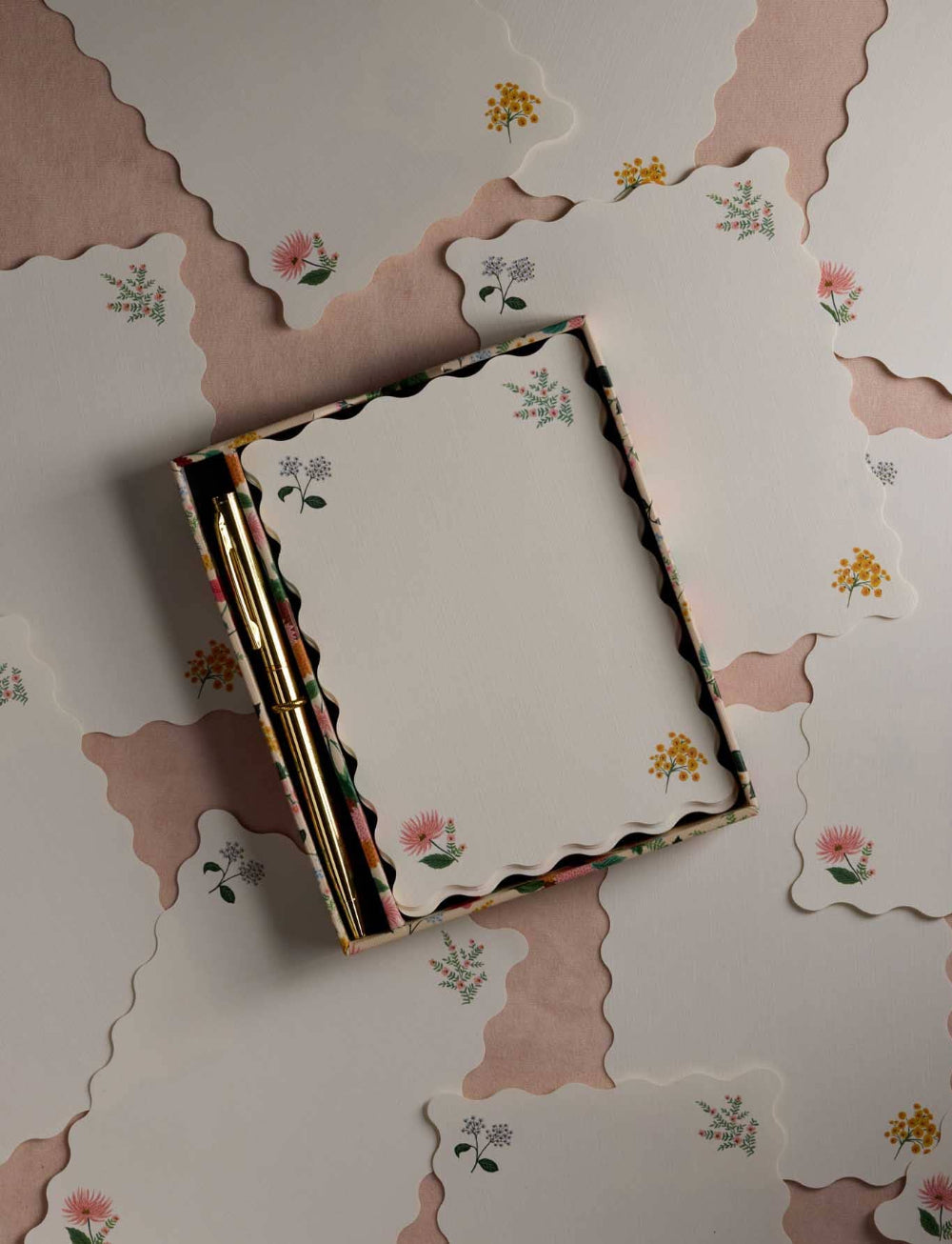 Floral notebook and pen on a matching floral-patterned surface