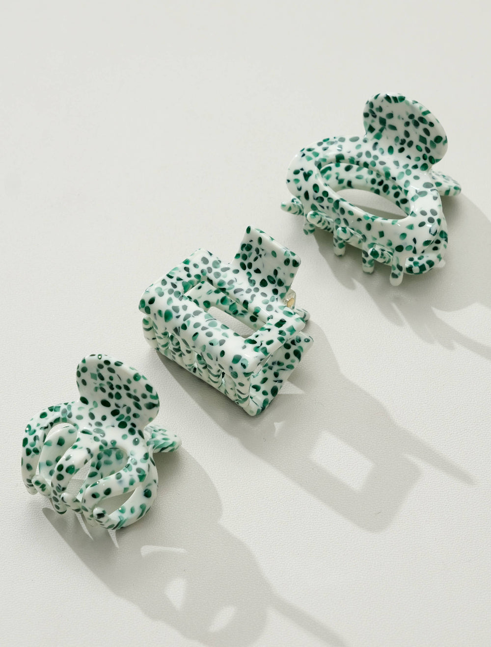 Green and white patterned hair clips on a light background