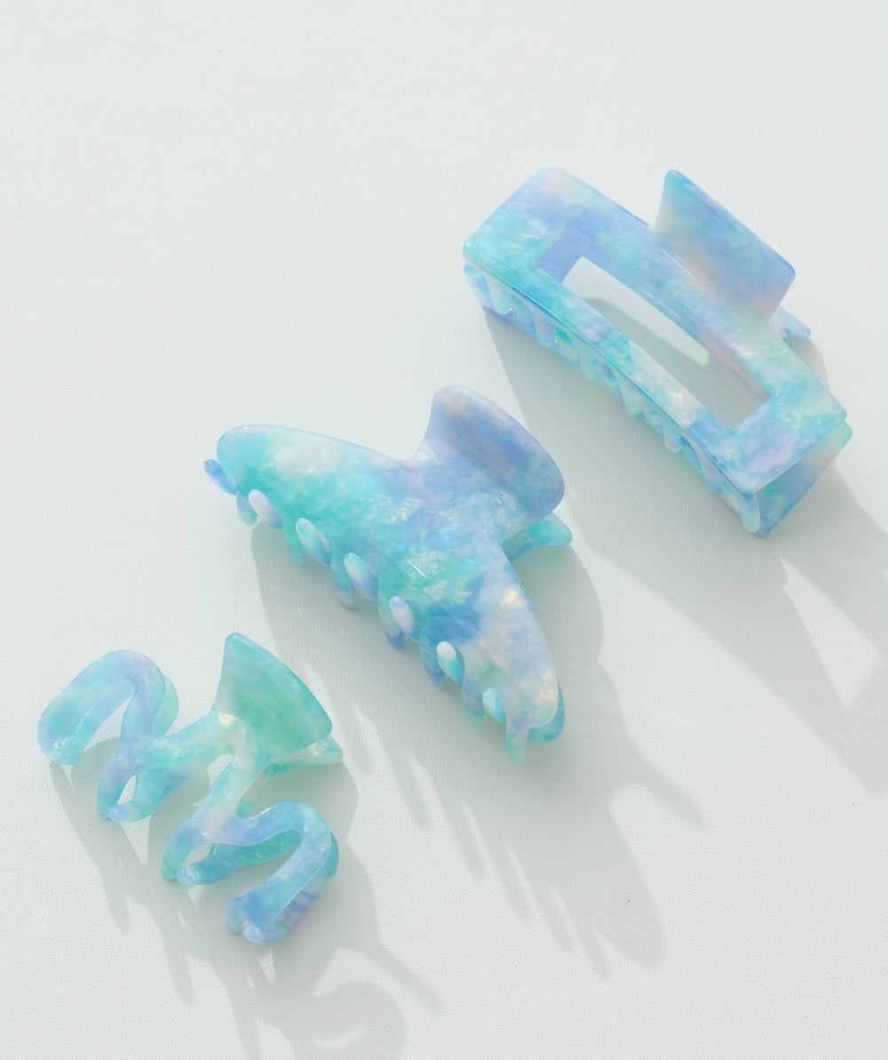 Set of 3 blue and green hair clips on a white background