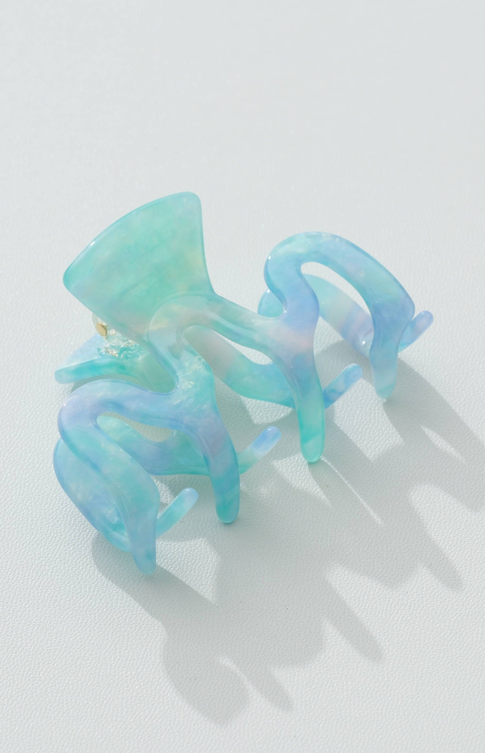 Pair of blue and green clips on a light gray background