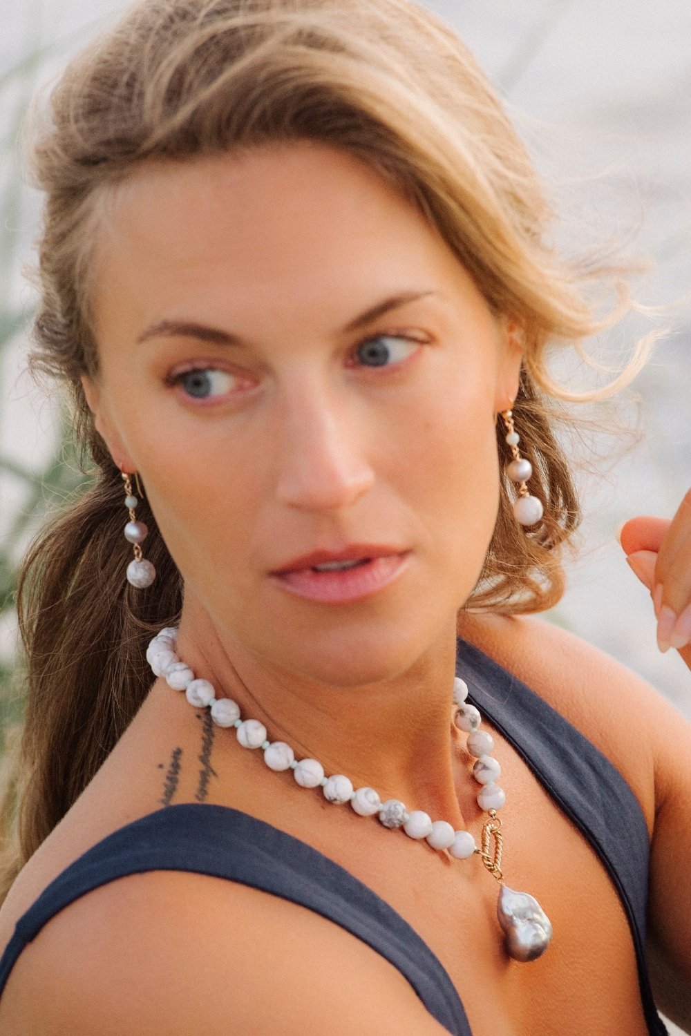 Woman wearing a seamist howlite necklace and matching earrings outdoors