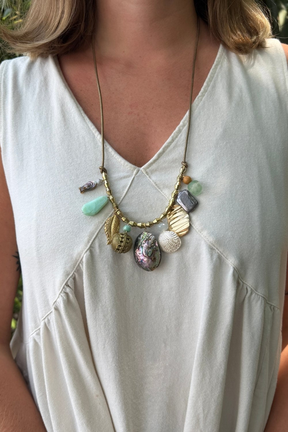 Necklace with colorful pendants on a white sleeveless top