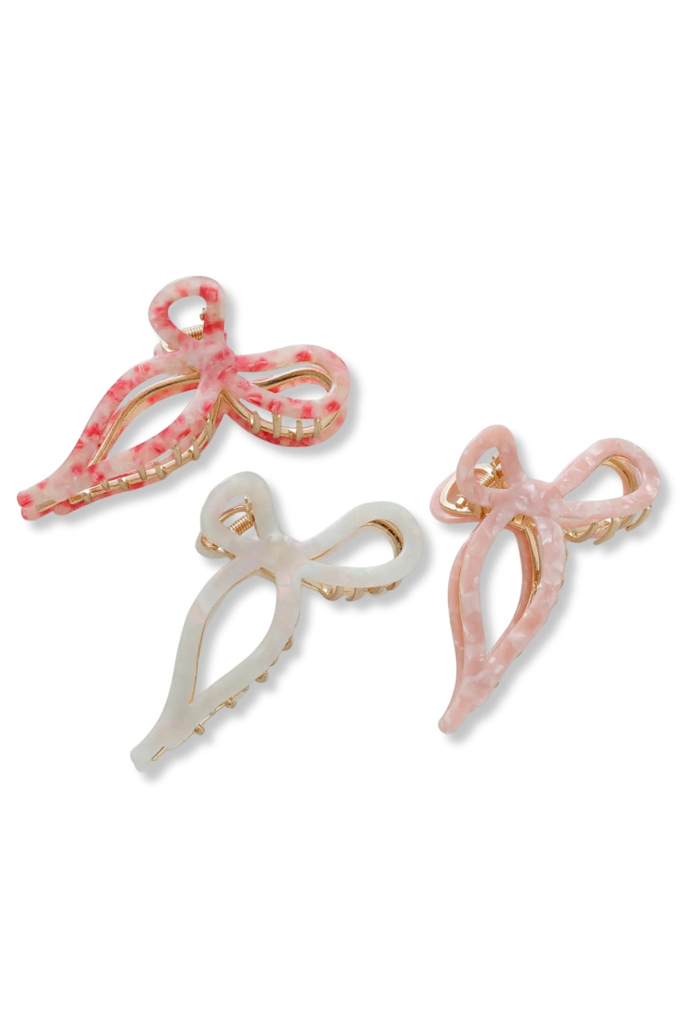 Three bow-shaped hair claw clips in pink and white marbled resin with gold-tone metal edges, displayed on a clean white background.