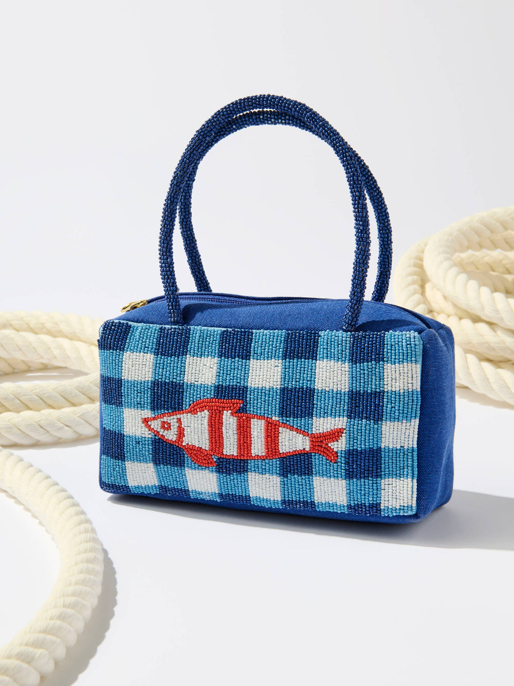 blue beaded mini bag with fish motif and ropes in background