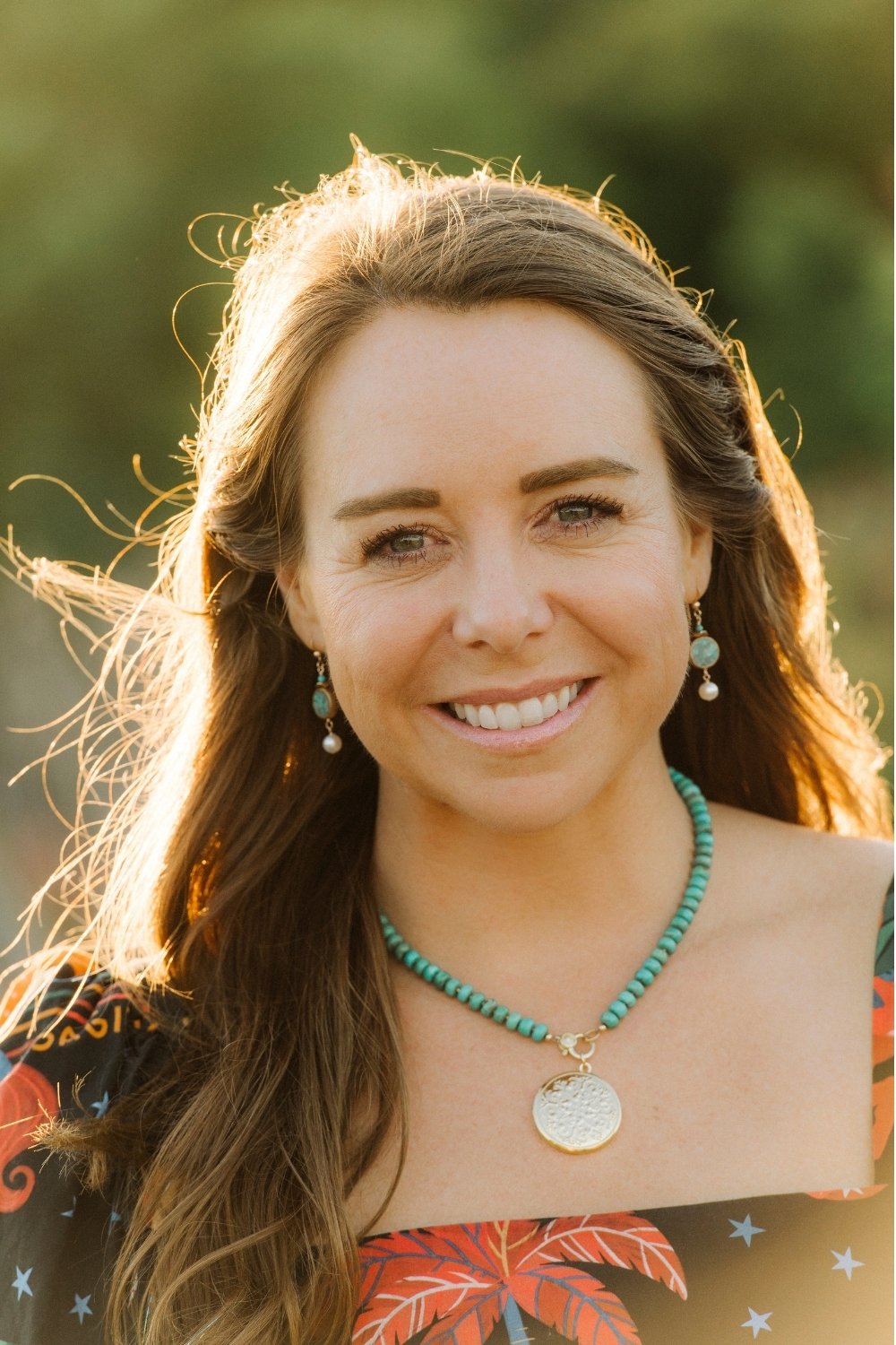 Woman wearing a bora bora turquoise necklace with a blurred natural background