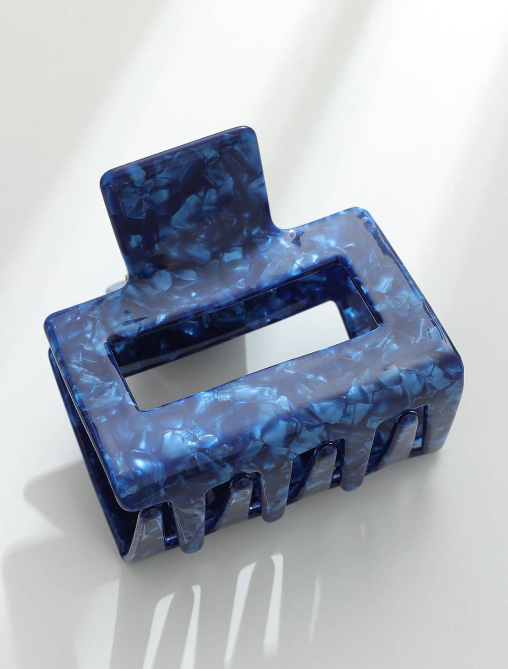 Blue marbled hair clip on a white background