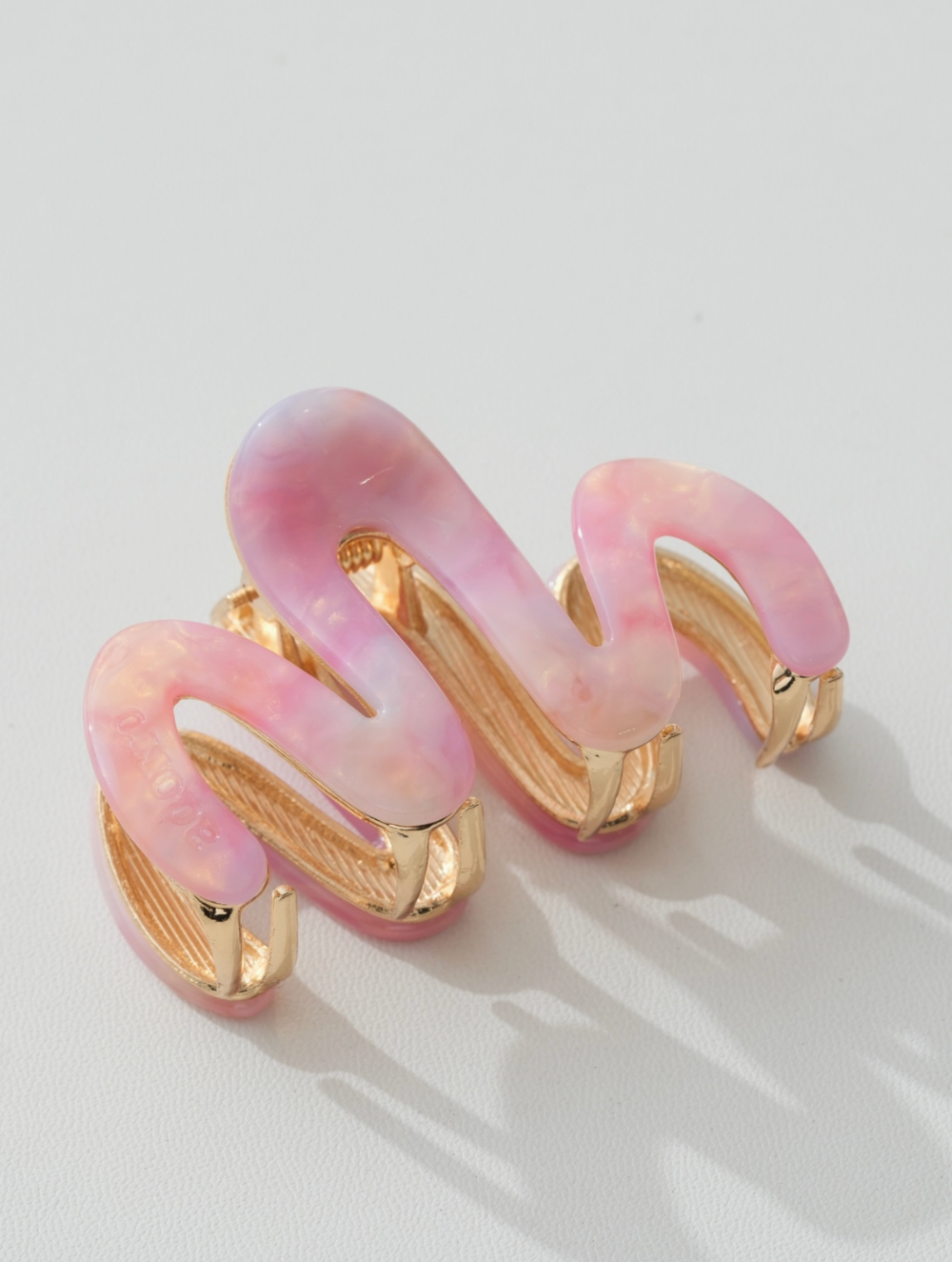 Pink and gold clip on a light background