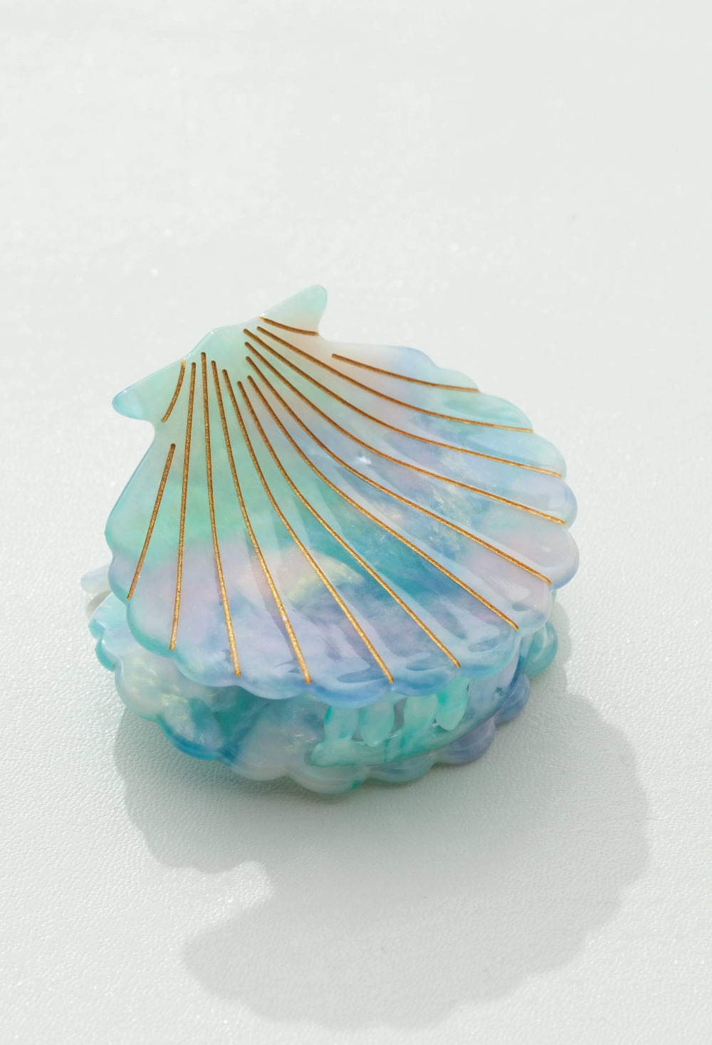 blue shell claw clip with gold accents on a white background