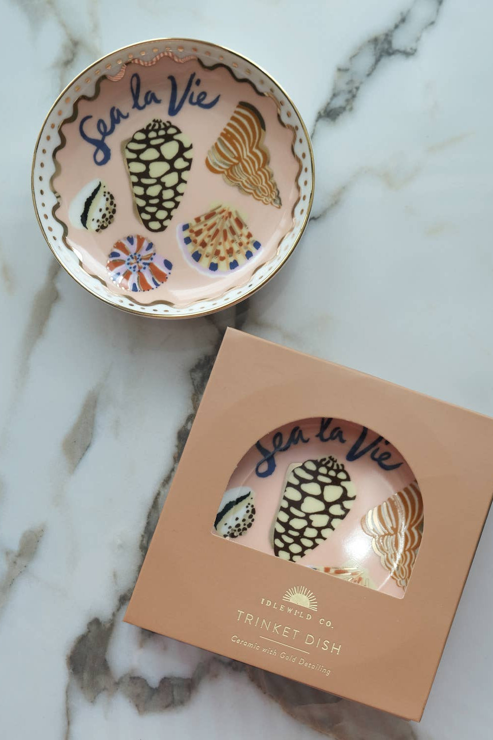 Decorative trinket dish with 'Sea la Vie' text and packaging on a marble surface