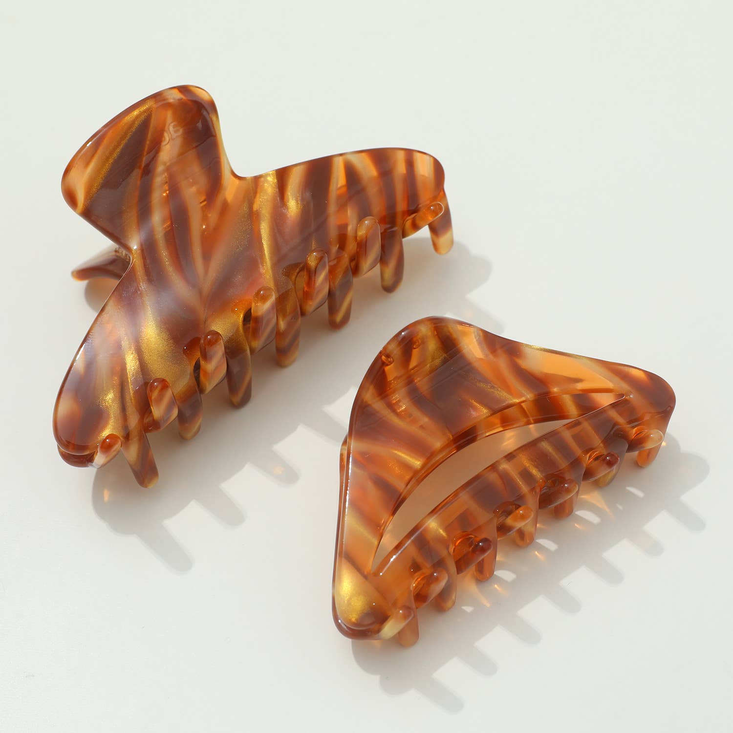 Two tortoiseshell patterned hair clips on a light background