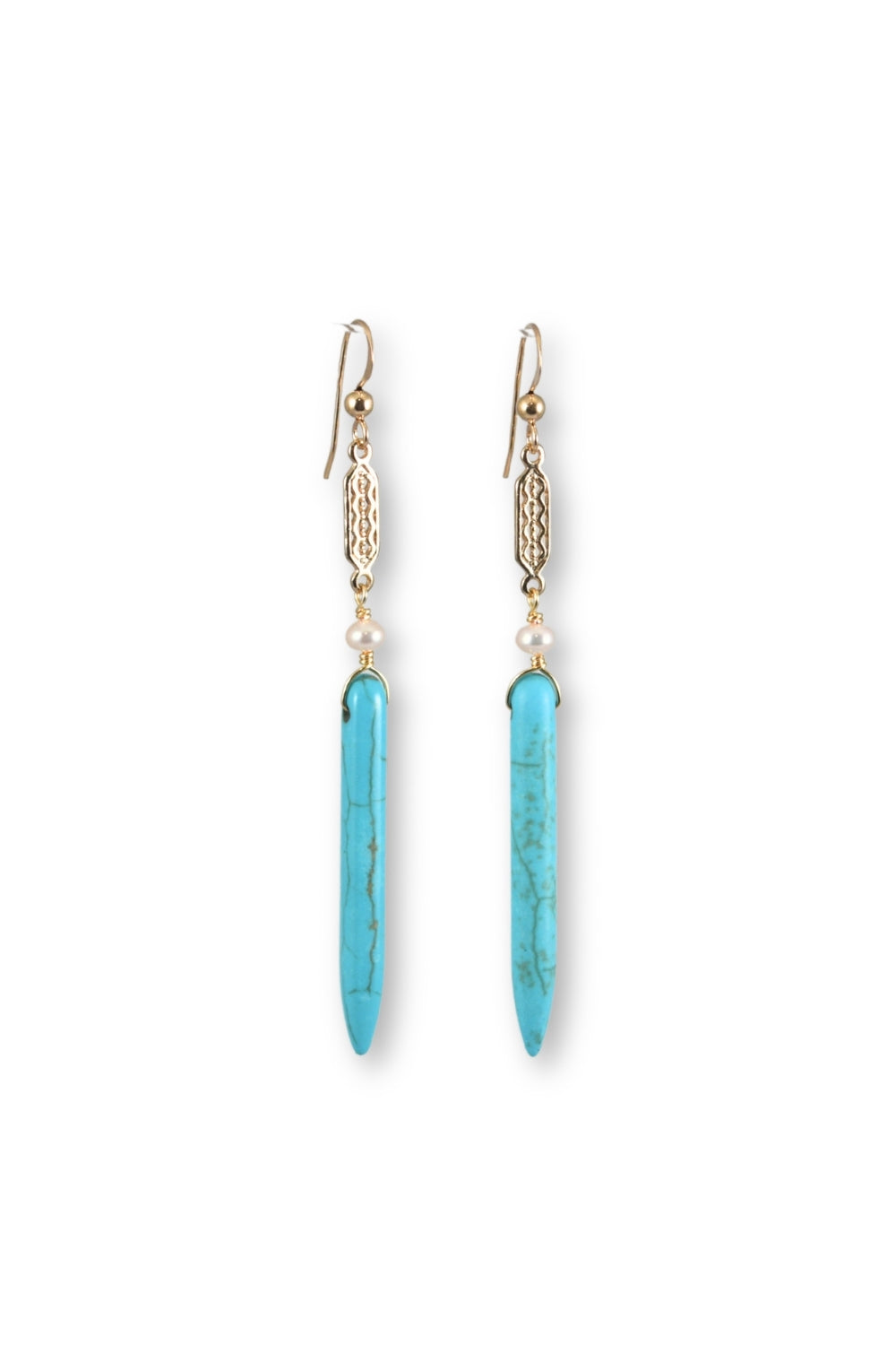 A pair of drop earrings featuring long, tapered turquoise-blue stone pendants with natural marbling, suspended from gold-toned filigree details and small white beads on a plain white background.